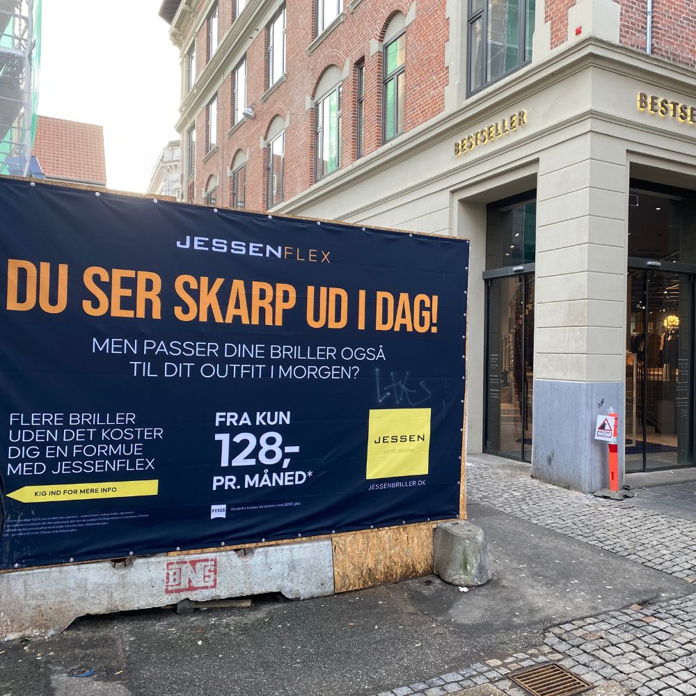 Butiksfacade med PVC-banner ved indgang (Bestseller)